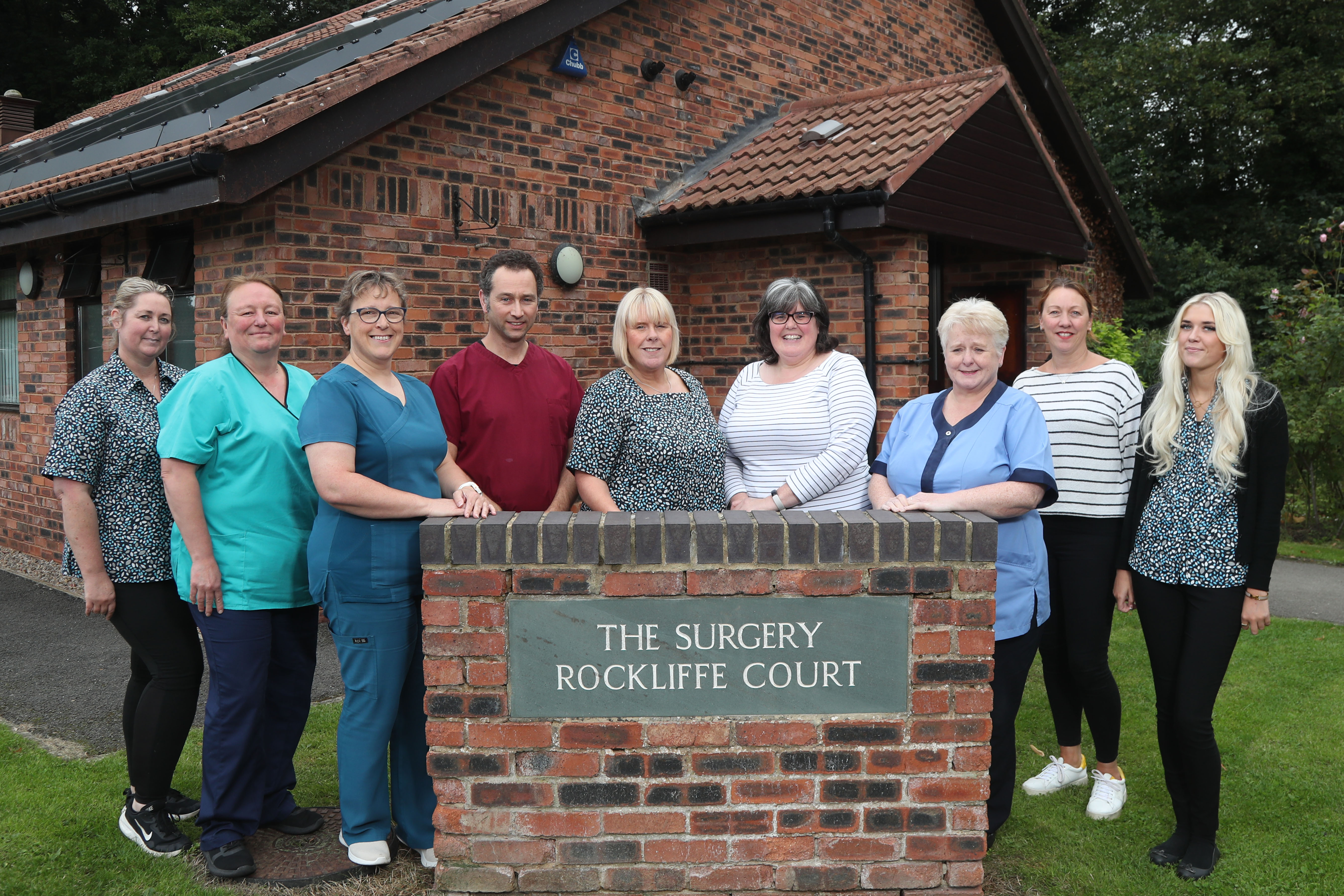 Nine health professionals stood outside GP practice