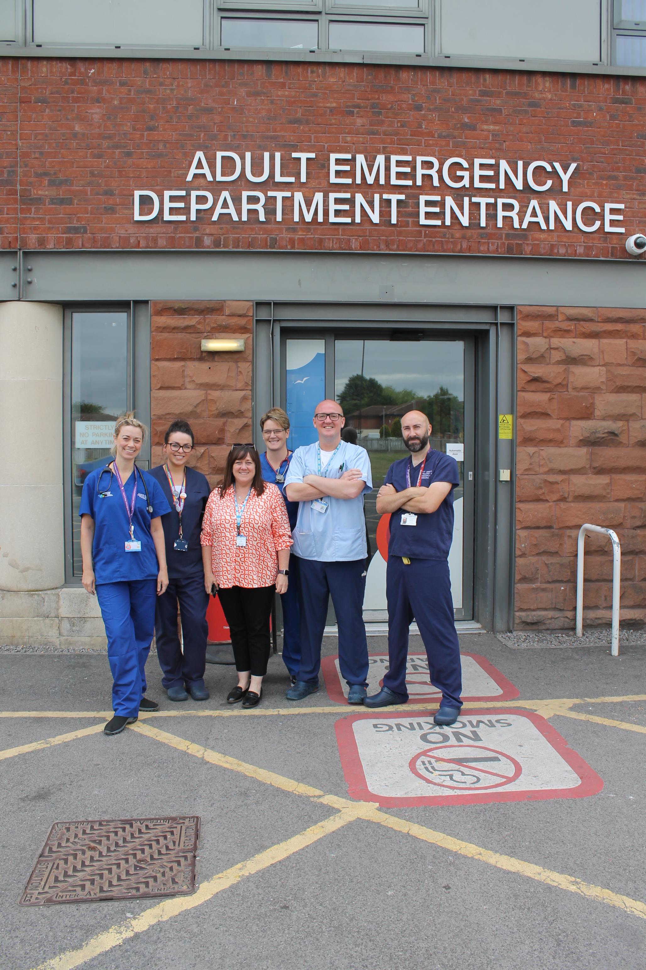 Six health professionals stood outside emergency department